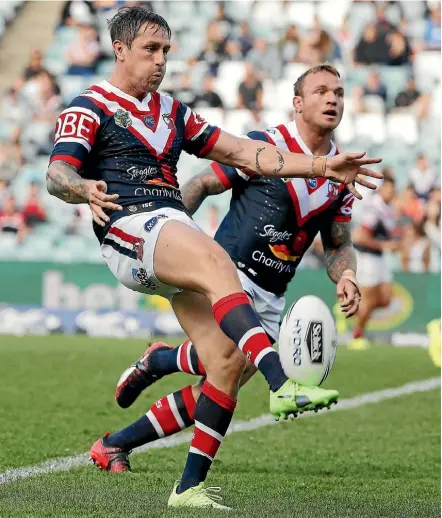  ??  ?? Mitchell Pearce kicks for territory for the Roosters against the Titans in Sydney yesterday.