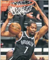  ?? Corey Sipkin ?? LIKE OLD TIMES: Kevin Durant, looking like the old Kevin Durant, slams home two of his 22 points in Tuesday’s Nets victory in their season-opener.