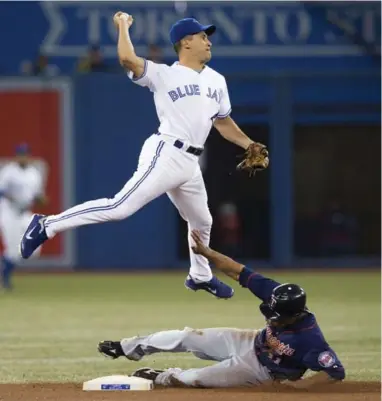  ?? MARK BLINCH/REUTERS ?? Still amazing agile at age 45, Jays shortstop Omar Vizquel throws to first over sliding Twin Ben Revere during the first inning of his final major-league game Wednesday night. The sure-fire Hall of Famer is retiring after 24 seasons in the bigs.