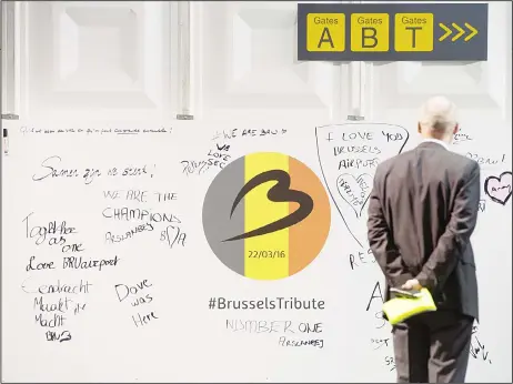  ??  ?? A man looks at solidarity messages written at the temporary check in terminal at Brussels Airport, in Zaventem, Belgium, April 3. Under extra security, three Brus
sels Airlines flights, the first for Faro in Portugal, are scheduled to leave Sunday...