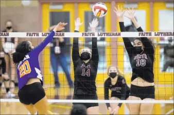  ?? Ellen Schmidt Las Vegas Review-journal @ellenschmi­dttt ?? Bishop Gorman’s Sophia Ewalefo (20) spikes while Faith Lutheran’s Ella Runstad (14) and Haylee Strong (18) goforthe block during their match Wednesday at Faith Lutheran.