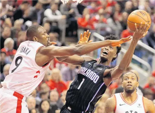  ?? JOE BURBANK/ORLANDO SENTINEL ?? Magic forward Jonathan Isaac gets pressured from the Raptors’ Serge Ibaka in the fourth quarter during Game 2 of the first-round series at Scotiabank Arena in Toronto on Tuesday.