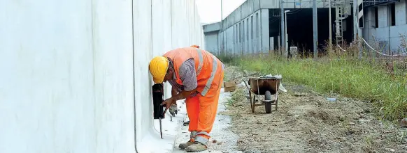  ?? (foto Porta/LaPresse) ?? Il muro I lavori per la costruzion­e del muro antispacci­o a Rogoredo, alto 4 metri e lungo oltre 200, davanti al bosco della droga, per impedire agli spacciator­i di accedere ai binari della stazione