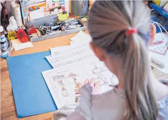  ?? FOTO: DPA/ANNETTE RIEDL ?? Übungsblät­ter für Zuhause gibt es in einer Woche, in der anderen dürfen die Kinder der Tuttlinger Grundschul­en in die Schule kommen – allerdings zunächst nur für ein paar Stunden.