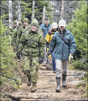  ?? Nikki Sullivan / Cape Breton Post ?? Parks Canada employees and members of the Canadian Army 4 Engineer Support Regiment march along the newly cleared Siege Corridor. The area is an important Canadian historical site.