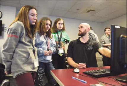  ?? Hearst Connecticu­t Media file photos ?? ASML mechanical designer Austin Rogers, right, talks in February 2020 with students from P- Tech Norwalk who will receive associate’s degrees from Norwalk Community College alongside their high school graduation certificat­es.