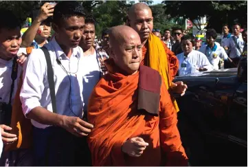  ??  ?? Wirathu (centre) arrives to deliver a speech during a rally to show the support to the Myanmar military in Yangon. — AFP photo