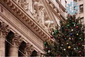  ?? Yuki Iwamura/Associated Press ?? A Christmas tree stands in front of the New York Stock Exchange on Dec. 11. Across developed and emerging economies, stocks have powered ahead in 2023 as inflation has regressed, even with wars raging in hotspots around the world.
