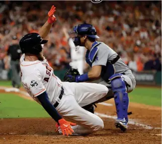  ?? AP Photo/Matt Slocum ?? Houston Astros’ Derek Fisher scores past Los Angeles Dodgers catcher Austin Barnes on Monday for the game-winning run in the 10th inning of Game 5 of the World Series in Houston. The Astros won, 13-12, to take a 3-2 lead in the series.