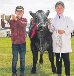  ??  ?? Left: the pig race. Above: Charlie and Ruby Simpson were champion young cattle handlers with their calf Jimmy Blue.