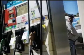  ?? THE ASSOCIATED PRESS ?? Motorist Jerry Reed watches the pump display while filling up his tank at a gas station Thursday in Atlanta. The U.S. is on track for the lowest annual average gas price since 2010— and the 2015averag­e is expected to be lower.