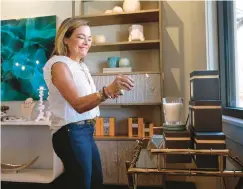  ?? ?? Susie Busch Transou, owner of Hearth & Soul, lights a candle Sept. 9. The store supports nonprofit organizati­ons each month by donating the net profits from special candle sales.