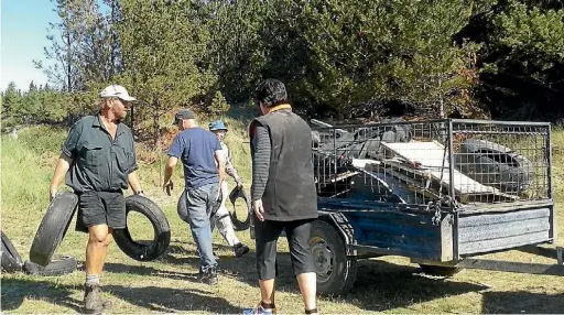  ??  ?? Darren Clarke, Jackie Clarke, Greg Taylor and David Burt load up a trailer at the annual Rabbit Island clean up.