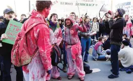  ??  ?? BRUSSELS: Demonstrat­ors wearing paint splattered clothes protest outside of an EU-Canada summit at the European Council building in Brussels yesterday. —AP