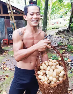  ??  ?? A LANZONES farmer shows off his harvest