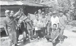  ??  ?? BANTUAN: Christoper (tiga kanan) menyampaik­an sumbangan kepada salah seorang penerima di Kampung Lingkabung­an.