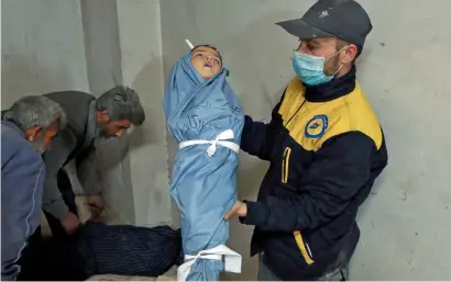  ?? AFP ?? A Syrian medic displays the body of a child at a makeshift clinic after a chemical attack on the rebel-held village of Al Shifuniyah in the Eastern Ghouta region on the outskirts of Damascus. —