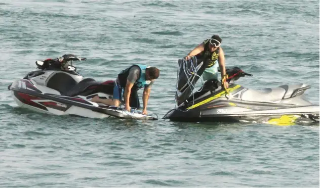  ?? John Varughese / Gulf Today ?? ↑
The riders are fixing the problems of jet skis.