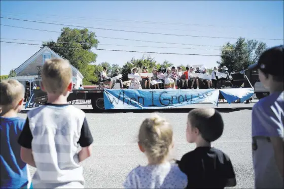  ?? BRIDGET BENNETT/LAS VEGAS REVIEW-JOURNAL FOLLOW @BRIDGETKBE­NNETT ?? A parade float passes children watching from a sidewalk during Pioneer Day on Saturday in Panaca, Nev. The annual celebratio­n in the tightknit town came only 10 days after a bombing in which a 59-year-old man was killed and several families displaced.