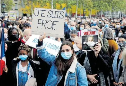 ?? [ Reuters] ?? „Ich bin Lehrer“: Menschen in Paris demonstrie­ren für den von einem Islamisten enthauptet­en Lehrer Samuel Paty.