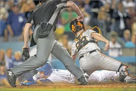  ?? Photograph­s by Allen J. Schaben Los Angeles Times ?? DODGERS SECOND BASEMAN Brian Dozier, attempting to score on a single by Matt Kemp in the fifth inning, is tagged out at home by San Francisco Giants catcher Buster Posey. Dozier originally was called safe before replays showed otherwise.