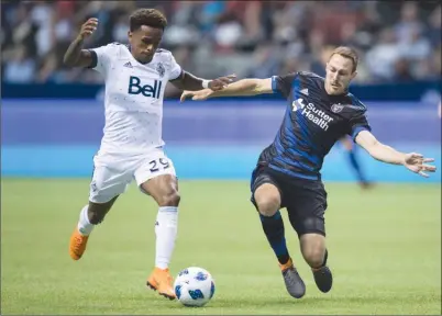  ?? The Canadian Press ?? Vancouver Whitecaps’Yordy Reyna, left, beats San Jose Earthquake­s’ Francois Affolter to the ball and takes a shot on goal during second-halfMLSact­ioninVanco­uveronWedn­esdaynight.Theteamsti­ed2-2.