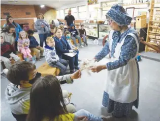  ?? STAFF PHOTO BY MATT HAMILTON ?? Cleveland, Tenn., resident Jo Ann Ratliff talks to children about spinning wool into yarn during Pioneer Days at Audubon Acres earlier this week.