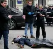  ?? FOTO REUTERS ?? Inspecteur­s onderzoeke­n het lichaam van Denis Voronenkov. Het Kremlin ontkent alle betrokkenh­eid.