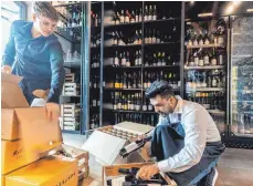  ?? FOTO: CHRISTIAN FLEMMING ?? Das gehört jetzt zu Farid Azizis Ausbildung­salltag: Mit Felix Epple sortiert er Weine.