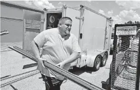  ?? [AP PHOTOS] ?? Troy Knutson loads supplies into a storage facility in Bradenton, Fla. Data shows that small businesses are hiring less, despite the strong economy, partly because they are losing employees to bigger firms.