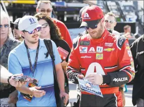  ?? Terry Renna / Associated Press ?? Dale Earnhardt Jr. gives autographs in the garage area during practice for Sunday’s NASCAR Cup Series race at Homestead-Miami Speedway in Homestead, Fla., Friday.