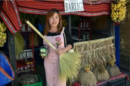  ?? Photo by Redjie Melvic Cawis ?? LOCALLY GROWN. Barlig lass Berna Nabunat shows organicall­y grown red rice and soft broom from the municipali­ty of Barlig during the Agro-Industrial Fair as part of the 51st Mountain Province Foundation Day and 14 Lang-ay Festival celebratio­n in Bontoc,...