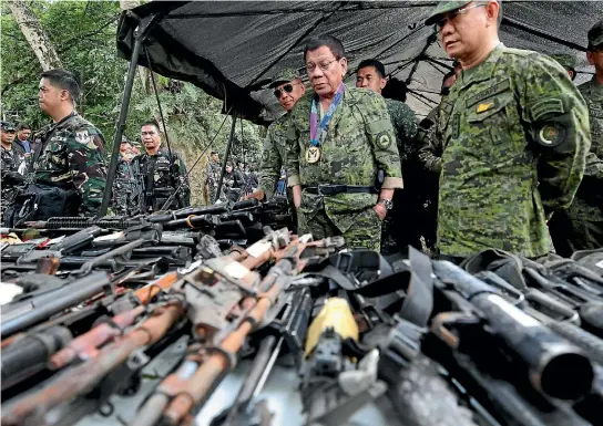  ?? PHOTO: REUTERS ?? Philippine President Rodrigo Duterte inspects firearms together with Eduardo Ano, Chief of Staff of the Armed Forces of the Philippine­s, during his visit at the military camp in Marawi city, southern Philippine­s.