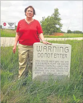  ?? PHOTO COURTESY OF SCOTT PRATT ?? Pine River Superfund Task Force Chair Jane Keon stands next to a tombstone, warning passersby of the contaminat­ion at the old Velsicol Chemical plant site in St. Louis.