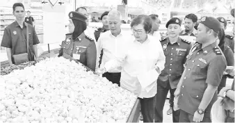  ??  ?? Christina, accompanie­d by Ministry of Domestic Trade, Cooperativ­e and Consumeris­m Tawau branch chief Sam Aminudin (right), inspecting the prices of goods at Giant Hypermarke­t.