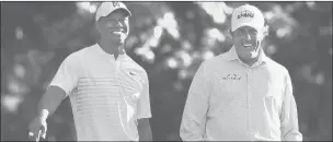  ?? AP ?? Tiger Woods, left, and Phil Mickelson share a laugh on the 11th tee box while playing a practice round for the Masters golf tournament April 3, 2018, at Augusta National Golf Club in Augusta, Ga.