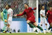  ?? FRANK AUGSTEIN - THE ASSOCIATED PRESS ?? Aziz Bouhaddouz Portugal’s Cristiano Ronaldo celebrates after he scored his third goal with a free kick during the group B match between Portugal and Spain at the 2018 soccer World Cup in the Fisht Stadium in Sochi, Russia, Friday.