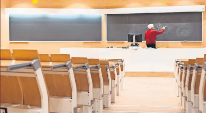  ??  ?? Un profesor imparte materia por videoconfe­rencia, con el aula vacía, durante el periodo del estado de alarma.