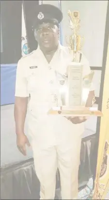  ??  ?? Assistant Superinten­dent Mitchell Novar Caesar with the trophy he was awarded for being first runner-up Caribbean Crime Fighter of the Year