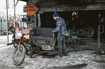  ?? Jay Janner / Associated Press ?? Nathan Lipson, owner of Metrocycle Pedicabs, looks at the damage Wednesday after a fire at his Austin warehouse. Lipson’s firm and Pedicab Adventures lost up to 100 vehicles.