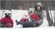  ?? MELISSA RENWICK TORONTO STAR FILE PHOTO ?? Wenona Arellado pushes Amai Rauch, front, and Zeke Shannon down a hill at Riverdale Park in Toronto.