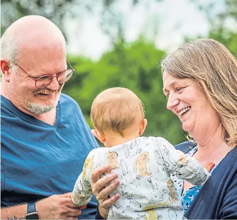  ?? ?? NURTURING: Christine and David Bartleman from Cupar, who have fostered for 10 years, enjoy a cuddle with one of the children currently in their care. Picture by Mhairi Edwards.