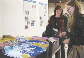  ?? NWA Democrat-Gazette/CHARLIE KAIJO ?? Emilee Dehmer of Nashville, Tenn., looks at a topographi­c model of the Arkansas 12 bridge over Beaver Lake during an opening Thursday at the Rogers Historical Museum.