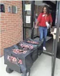  ??  ?? Nichele Gilling delivers prepared lunches to Kipling Elementary School in Deerfield, Ill. Food-delivery services are remaking school lunch. Kiddos Catering in Chicago provides restaurant meals to schools that contract with it.