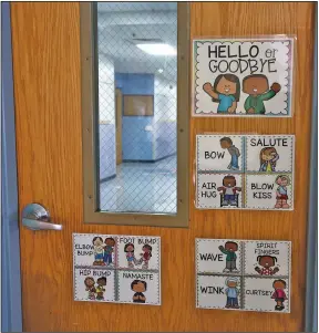  ?? (Arkansas Democrat-Gazette/Thomas Metthe) ?? Signs on a classroom door at Chicot Elementary School in Little Rock illustrate different ways for students to greet one another. Students and staff members will enter a new world of education when classes around the state start Monday.