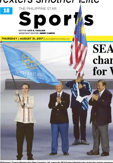  ?? AP ?? Philippine­s’ Foreign Minister Alan Peter Cayetano, left, waves the SEA Games federation flag during the closing ceremony of the 29th South East Asian Games in Kuala Lumpur, Malaysia. The Philippine­s will be the host country for 2019 30th SEA Games.