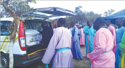  ??  ?? Members of Johane Masowe eChishanu Vadzidzi VaJesu Church prepare to carry a casket bearing the body of their church founder Aaron Mhukuta Gomo, popularly known as Mudzidzi Wimbo, at the gravesite in Goora, Madziwa, yesterday