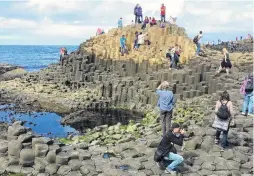  ??  ?? Dwarfed . . . Part of the Giant’s Causeway near where the basalt columns meet the sea.