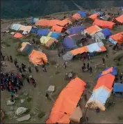  ??  ?? Nepalese villagers walks near their makeshifts tents at Laprak village in Gorkha district of Nepal on Monday.