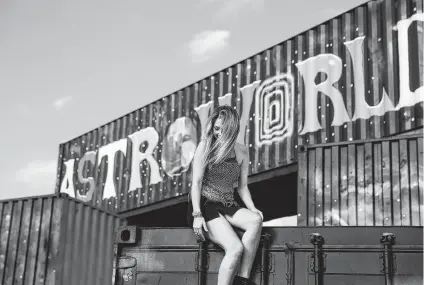  ?? Photos by Yi-Chin Lee / Staff photograph­er ?? Above: Jane Decleva climbs onto a shipping container and attempts to take photograph­s with the murals at Astroworld Festival at NRG Park. Center left: Friends Mayson Deane, from left, Kaci Alderin and Max Wright ride the merry-go-round. Center right: John Muniz dons his homemade Travis Scott tribute hat to the Houston rapper’s much-hyped music festival at NRG Park. Bottom : Ella Zimmerman, center, screams during a fall on the Mega Drop ride.